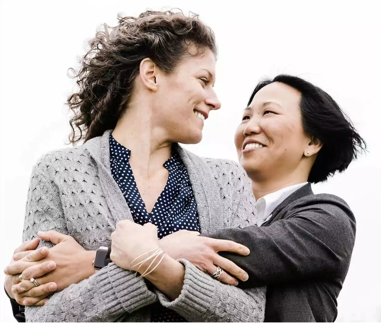 Two women smiling and hugging each other.