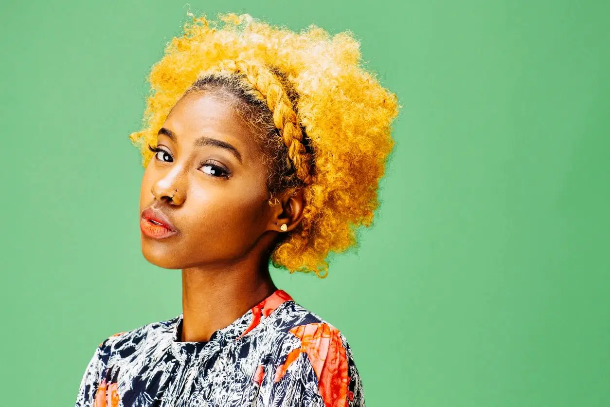 Woman with blonde afro and nose ring.