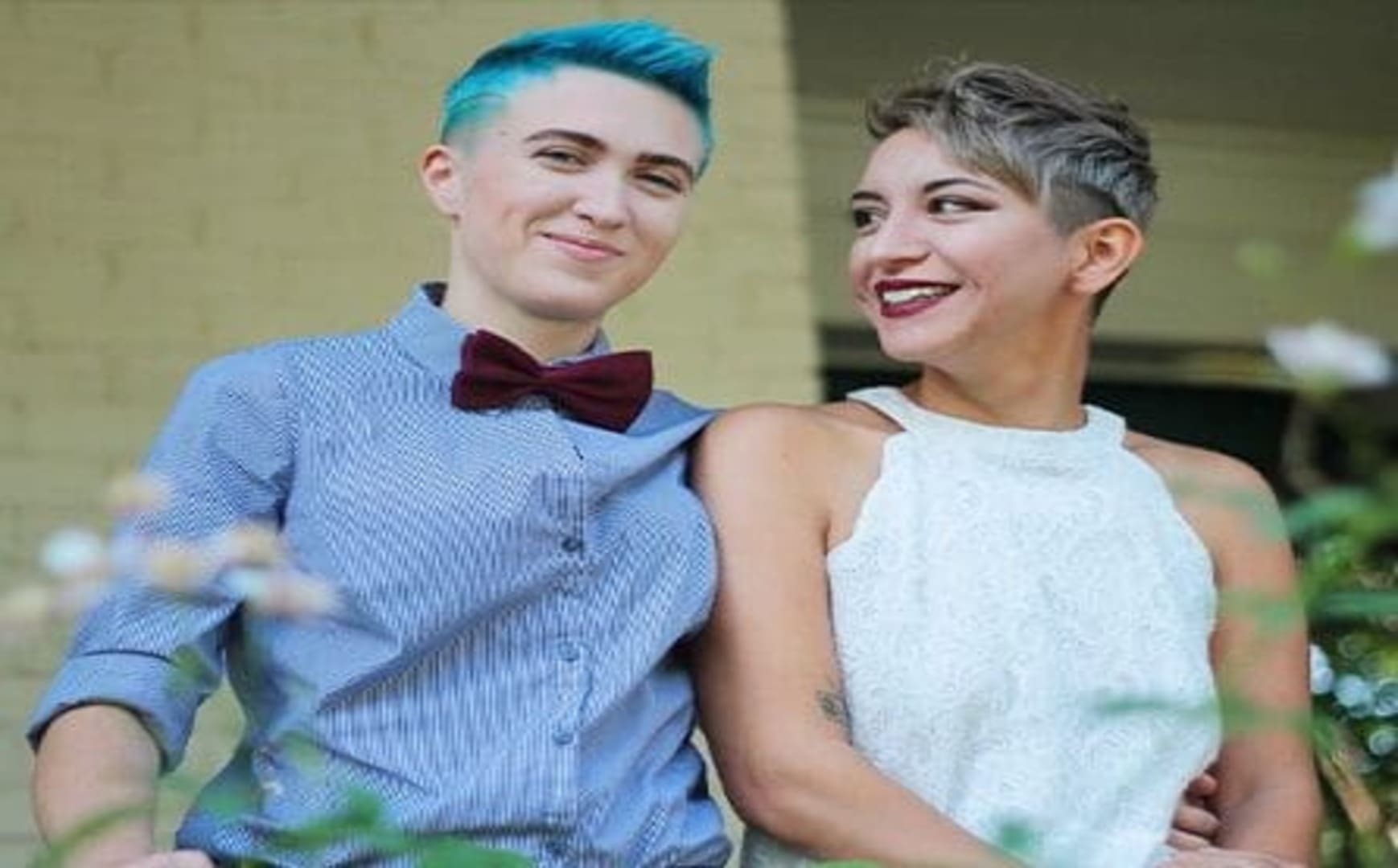 Two smiling women in a wedding setting.