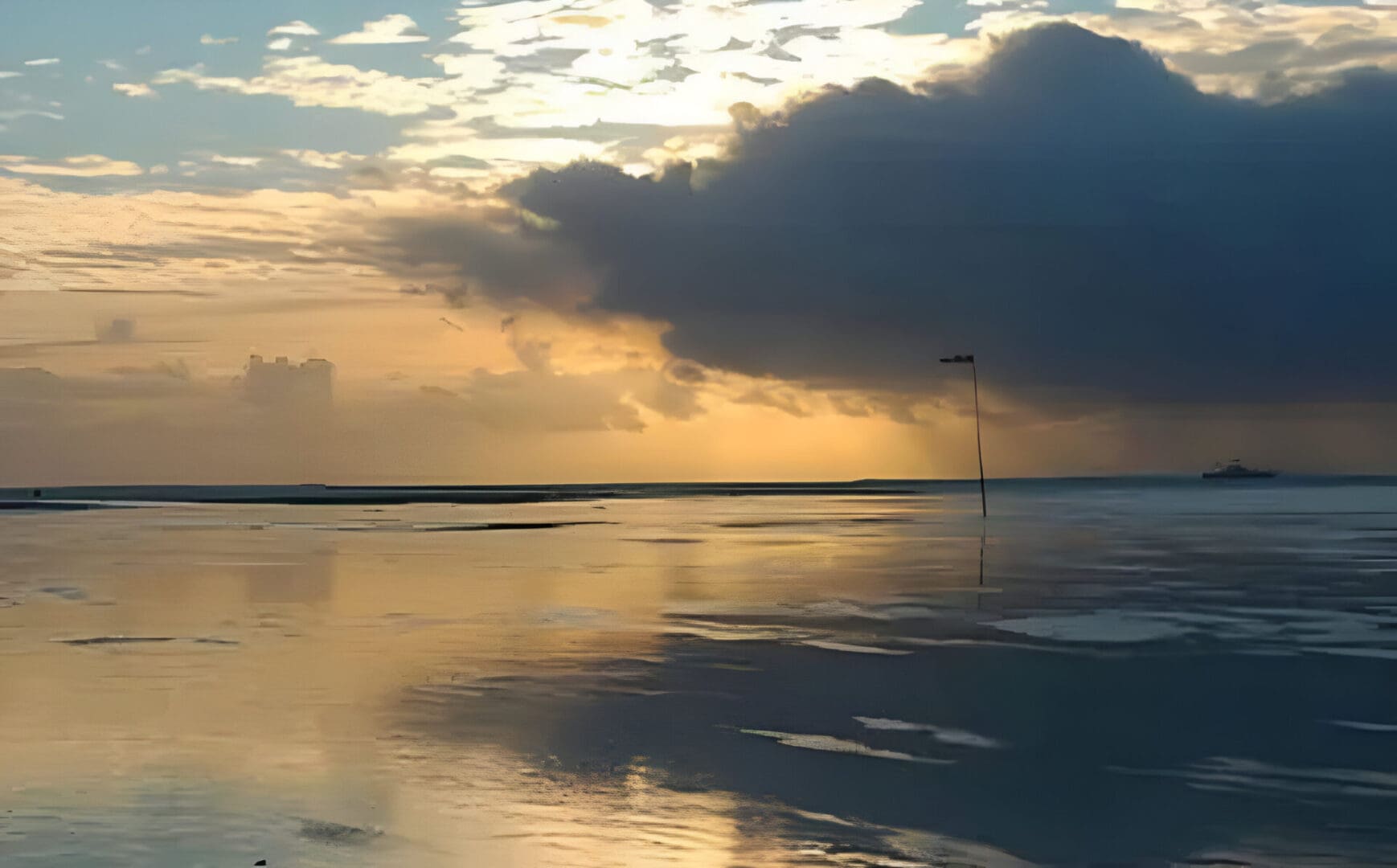 Calm ocean at sunset with a boat.